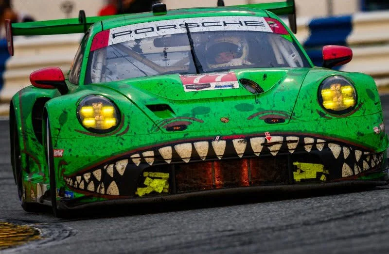 Grüner Rennwagen mit auffälligem Zahnmuster fährt auf der Strecke.